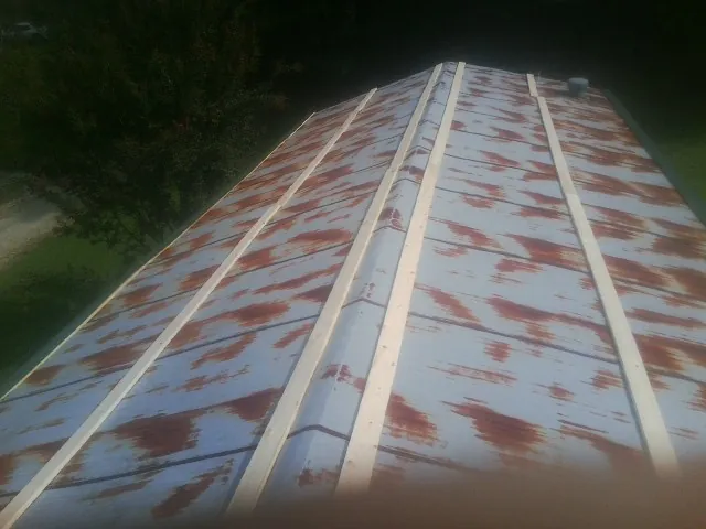 Rusted metal roof panels with new wood purlins before replacement — Storm Damage Roof Repair in Surgoinsville by Roofing Brothers